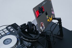 DJ Setup with Apple Macbook laptop on laptop stand. Audio-Technica DJ headphones plugged in to Pioneer DJ Console DDJ-SX.